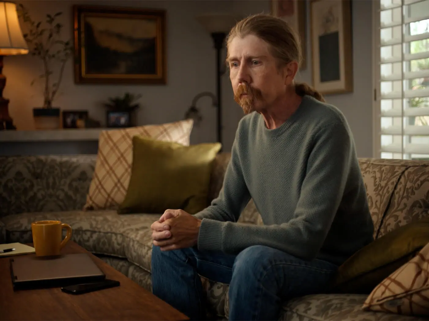 Dupuytren's contracture patient sits on a couch