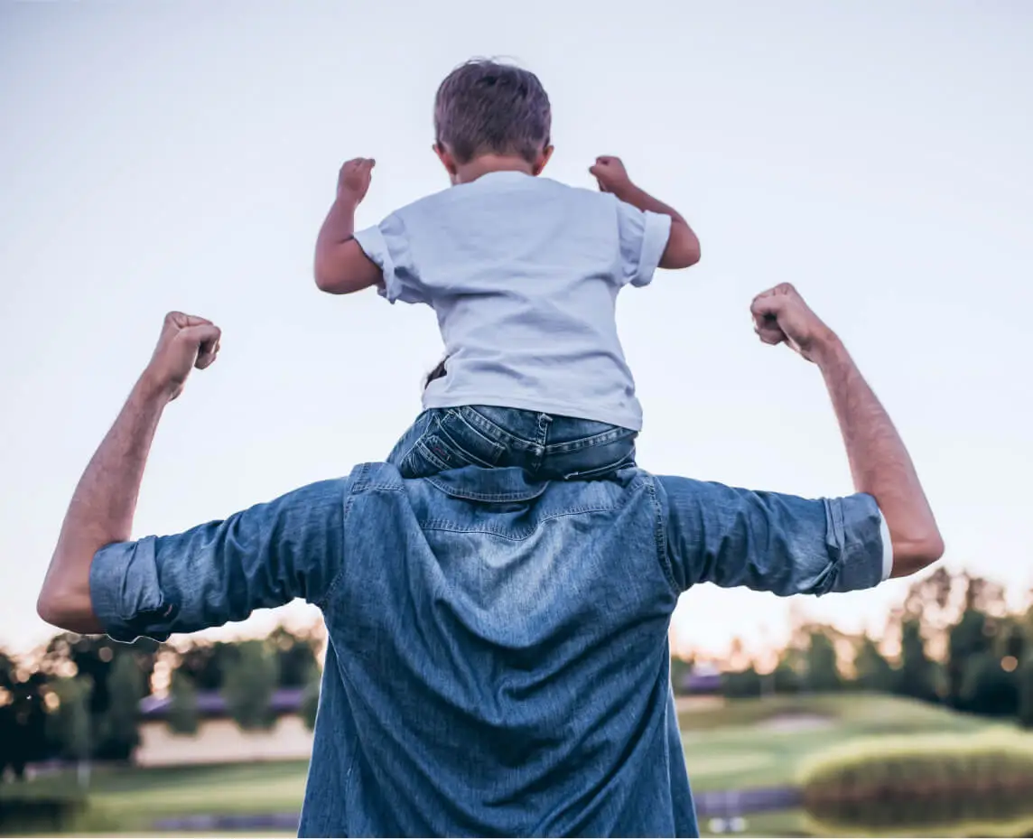 A father gives his son a shoulder ride.