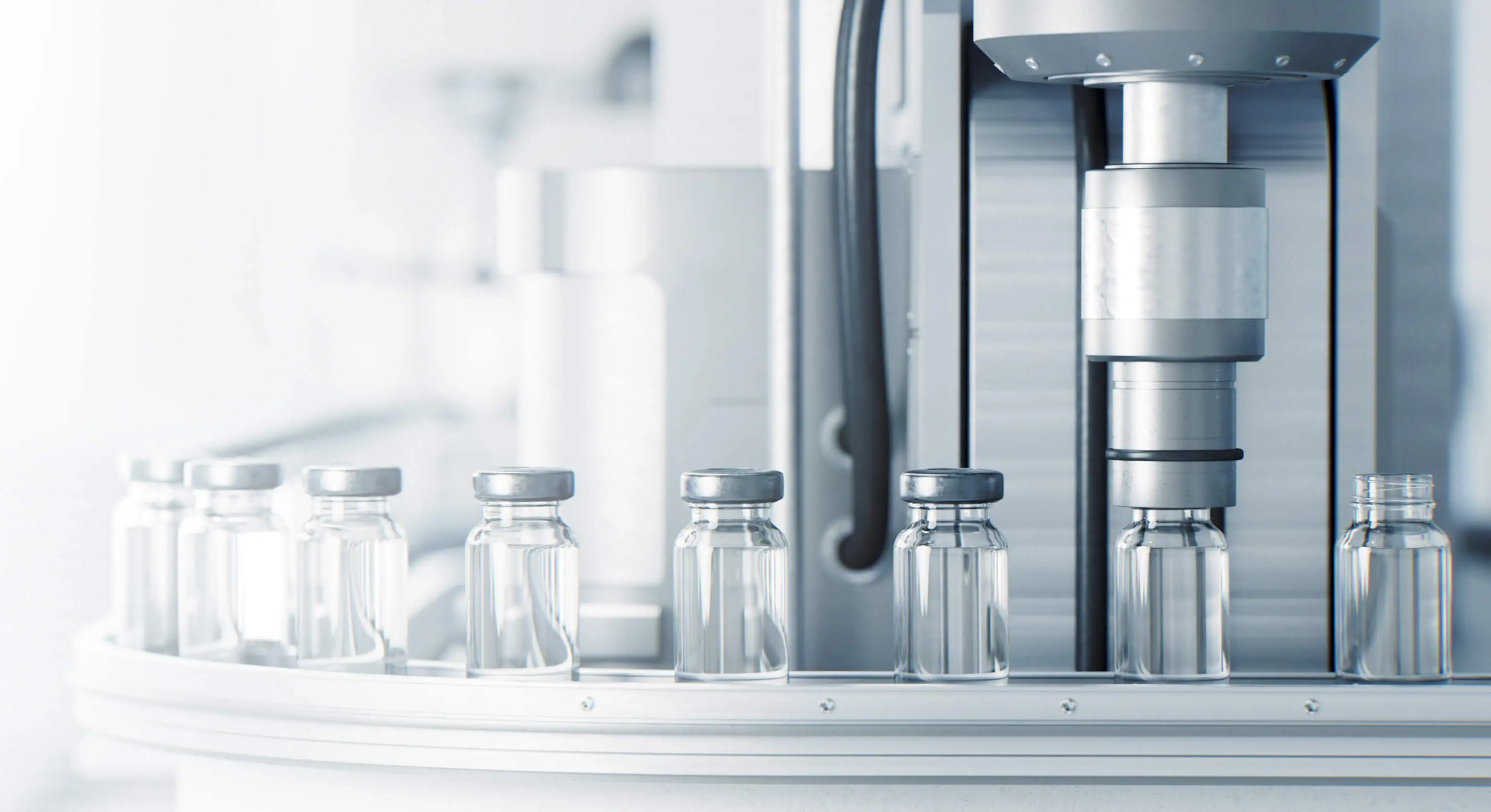 Empty medicine bottles wait to be filled by a machine.