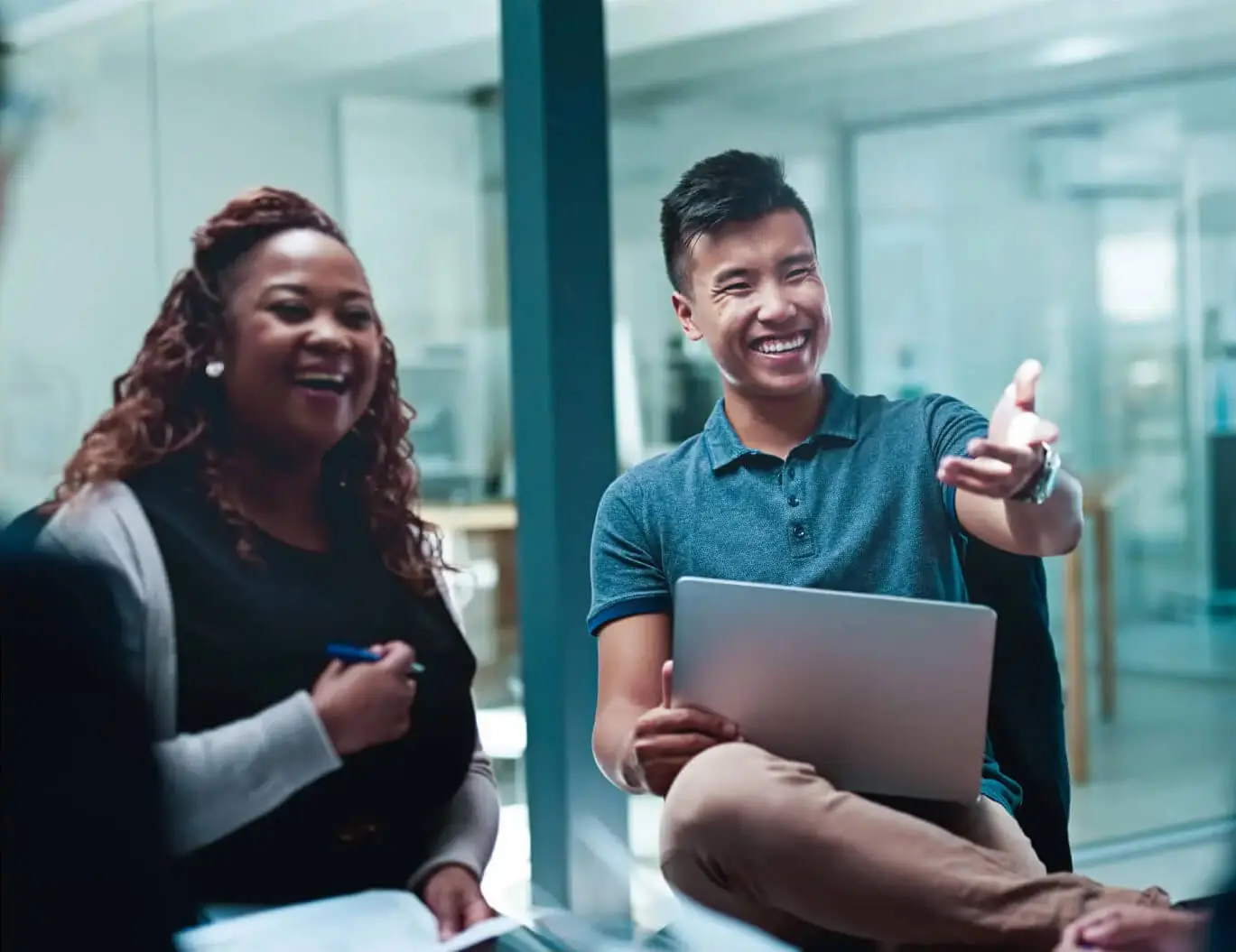 Two colleagues smile while in a meeting