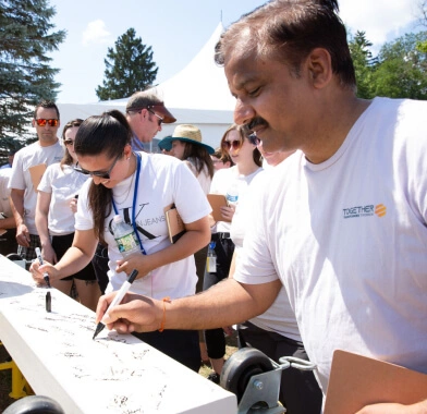 A group of people sign a banner