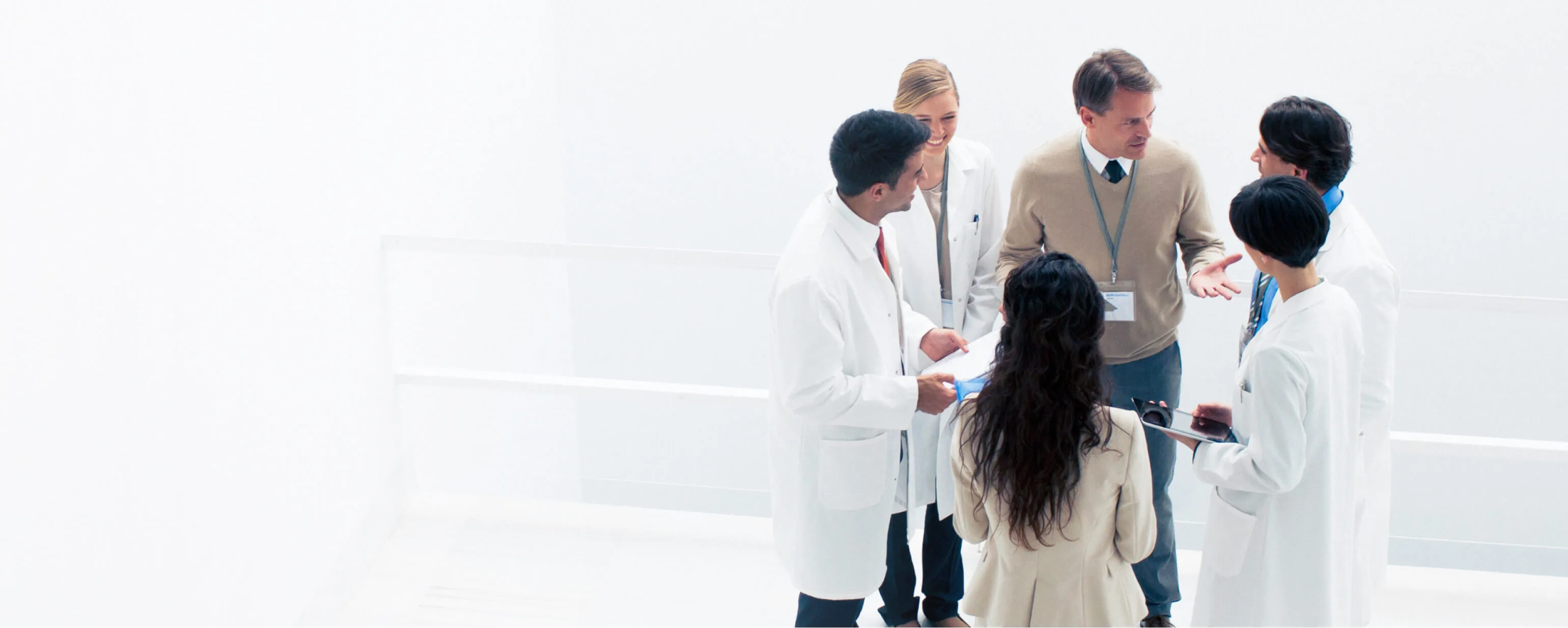 A group of medical professionals stand in a circle while in discussion.