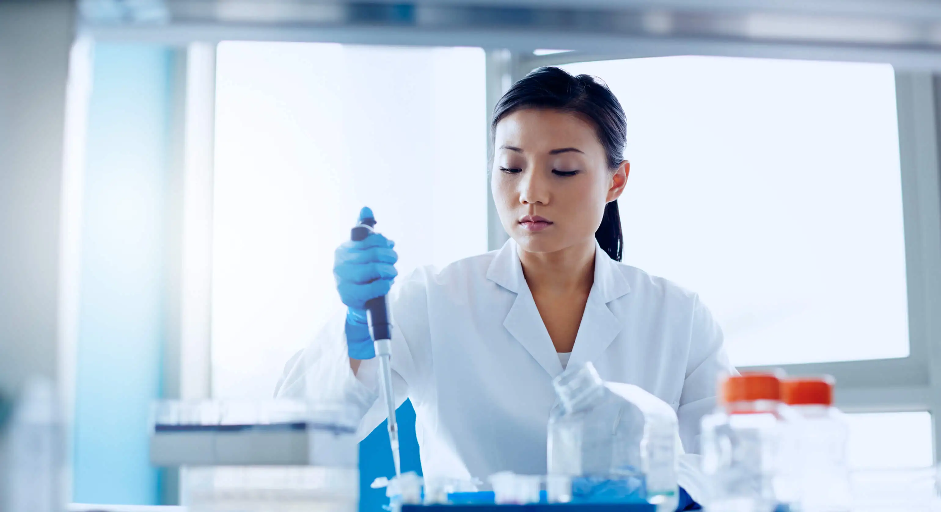 A scientist uses a dropper to mix liquid.