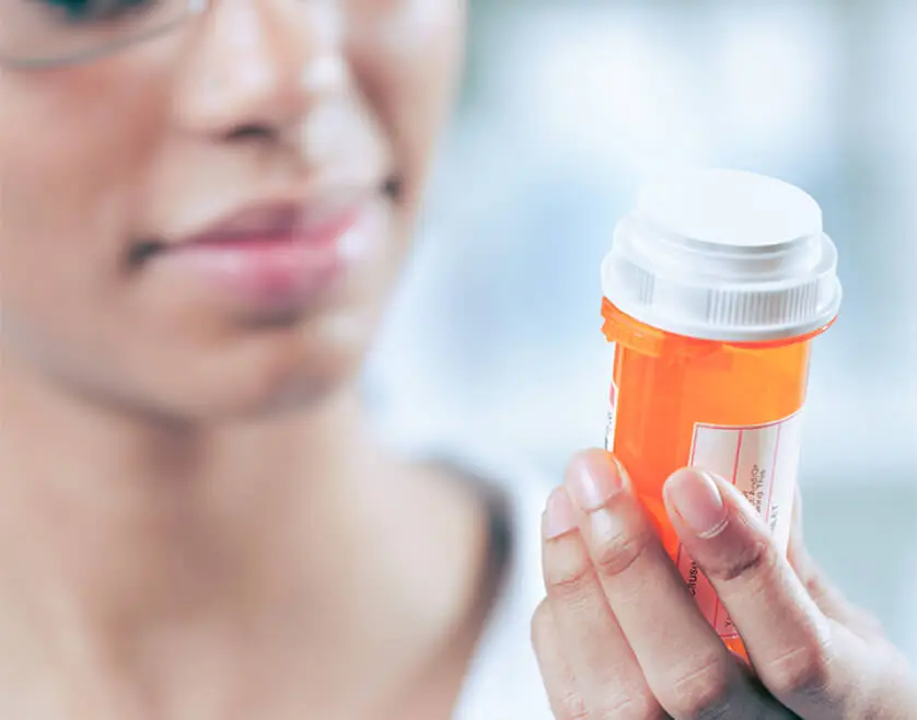 A closeup view of a person holding a prescription canister