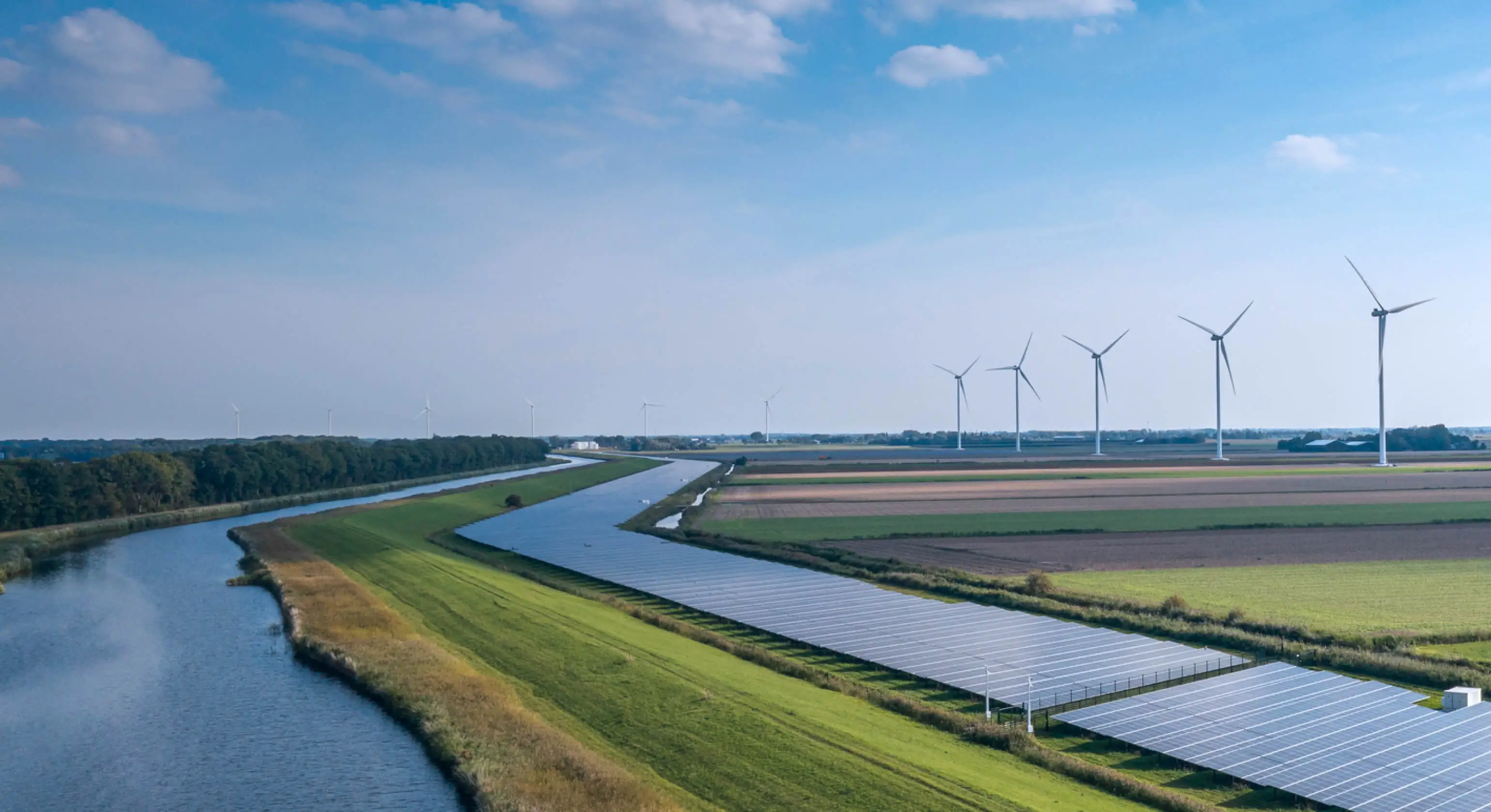 Farm with solar panels and energy generating windmills.